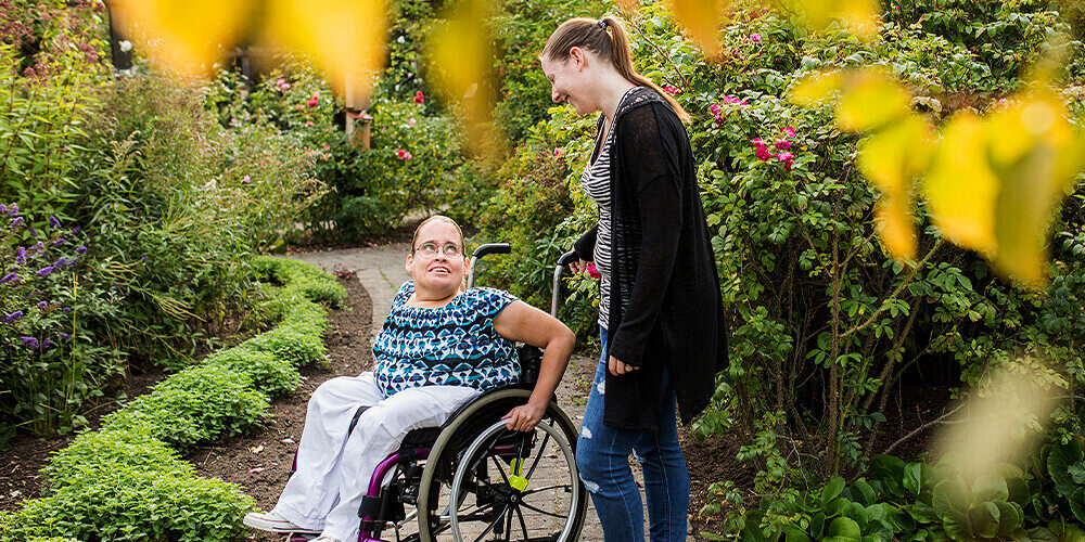 Support worker with client in gardens