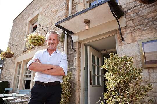 Man stands in front of pub he owns